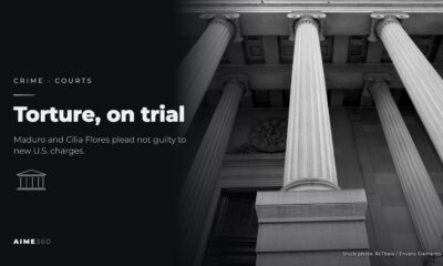 Stone columns on a courthouse facade, in black and white, beside the headline Torture, on trial